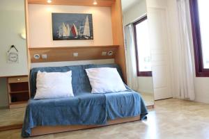 een slaapkamer met een bed met blauwe lakens en witte kussens bij Appt 2 pièces LA ROCHELLE - LR010-022 in La Rochelle