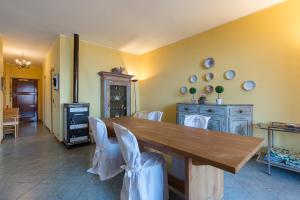une salle à manger avec une table en bois et des chaises blanches dans l'établissement Ca' del Bosco, à Stresa