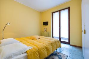 a yellow bedroom with a bed and a window at Ca' del Bosco in Stresa