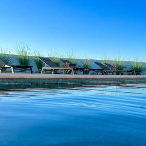 una fila de mesas y sillas junto a un cuerpo de agua en LAS DUNAS Cave House Holidays, en Benamaurel