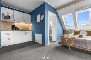 a bedroom with blue walls and a bed and a kitchen at Ferienwohnung Bude 2 Dagebüll in Dagebüll