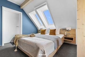 a bedroom with a large bed with blue walls and windows at Ferienwohnung Bude 2 Dagebüll in Dagebüll