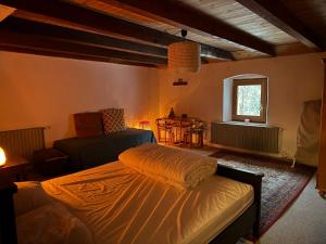 Un dormitorio con una cama y un sofá y una ventana. en Dharma Farm Retreat, en Mijoux