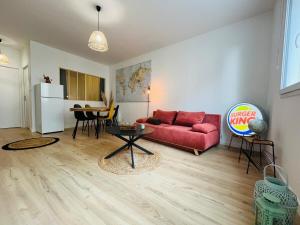 een woonkamer met een rode bank en een tafel bij Casa Diderot - T2 in Angers