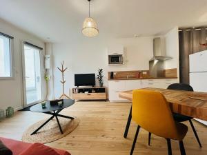 een keuken met een houten tafel en gele stoelen bij Casa Diderot - T2 in Angers +7 foto's
