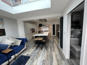 a living room with a blue couch and a kitchen at Whole house -Sleeps4-Parking-Garden-BikingHiking in Bury
