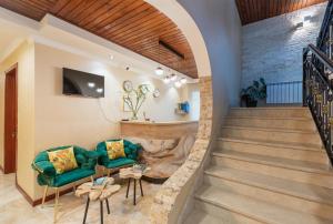 ein Wohnzimmer mit Treppe und einem grünen Sofa in der Unterkunft Hotel Gold Tower in Mestia