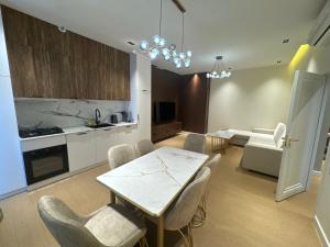 Una cocina y un comedor con mesa y sillas. en Skyline Towers Apartments, en Tashkent