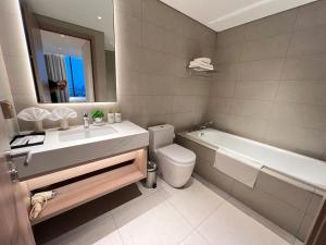 a bathroom with a sink and a toilet and a tub at Elegant Apartment Alacarte Hạ Long in Ha Long +95 photos