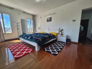 ein Schlafzimmer mit einem Bett und zwei Teppichen auf dem Boden in der Unterkunft Cloud Nine Kodai, Family Only Boutique Home Stay in Kodaikanal