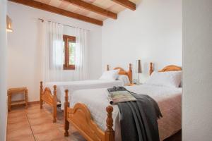 two beds in a bedroom with white walls and wood floors at Es Ravellar - Campos in Islas Baleares