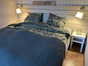 a bed with a blue comforter and pillows at Vindängs Gård Hagbards By in Slöinge