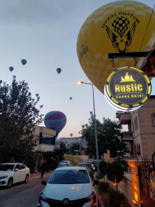 a bunch of hot air balloons flying over a street at Rustic Caves in Göreme +39 photos