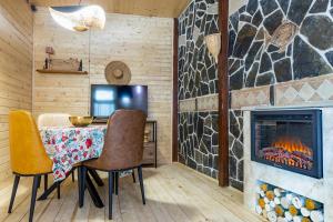 a dining room with a fireplace and a table and chairs at Mestia Alpine Cottage in Mestia