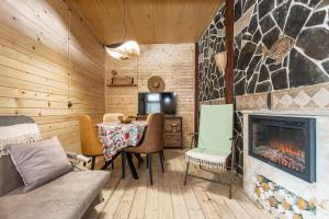 a living room with a table and a fireplace at Mestia Alpine Cottage in Mestia +9 photos