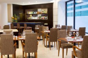 Un restaurante con mesas y sillas y un bar. en NH Buenos Aires Florida, en Buenos Aires