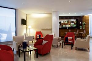 un vestíbulo del hotel con sillas rojas y un bar en NH Buenos Aires Florida, en Buenos Aires 20 fotos más