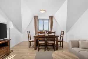una sala da pranzo con tavolo, sedie e divano di Esperia a Opatija
