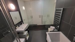 a bathroom with a sink and a tub and a mirror at Luxury Apt - View of the Center of Prague in Prague +47 photos