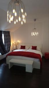 a bedroom with a large bed with red sheets and chandeliers at Luxury Apt - View of the Center of Prague in Prague