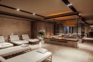 a lobby with two chairs and a table and a fireplace at Tivoli Portopiccolo Sistiana Wellness Resort & Spa in Sistiana
