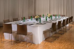 a long table with chairs and green bottles on it at Tivoli Portopiccolo Sistiana Wellness Resort & Spa in Sistiana