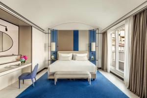 a bedroom with a large bed and a blue rug at Tivoli Portopiccolo Sistiana Wellness Resort & Spa in Sistiana