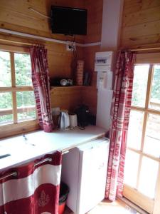 a kitchen with a counter and two windows and a television at Chalet Monts Jura in Mijoux