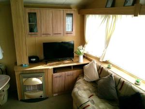 a living room with a couch and a flat screen tv at Highfields Rio 6 berth blow heated in Skegness