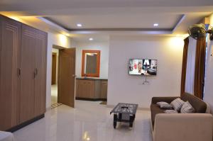 a living room with a couch and a table at Golden Grand by Xury Hotels in Tiruchchendūr