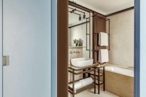 a bathroom with a tub and a sink and a bath tub at Tivoli Portopiccolo Sistiana Wellness Resort & Spa in Sistiana