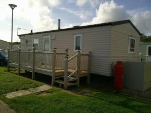 a small white house with a porch and a fire hydrant at Highfields Rio 6 berth blow heated in Skegness