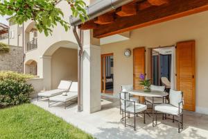 a patio with a table and chairs in a yard at Tivoli Portopiccolo Sistiana Wellness Resort & Spa in Sistiana