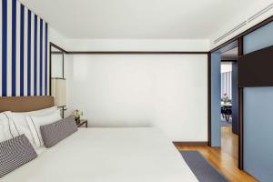 a bedroom with a white bed and a dining room at Tivoli Portopiccolo Sistiana Wellness Resort & Spa in Sistiana