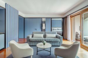 a living room with a couch and chairs and a table at Tivoli Portopiccolo Sistiana Wellness Resort & Spa in Sistiana
