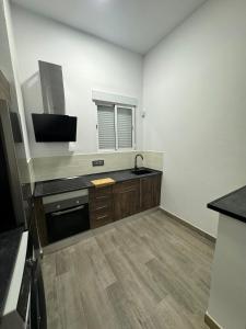 a kitchen with a sink and a tv on the wall at Apartamento Martina 1 in Mérida +5 photos