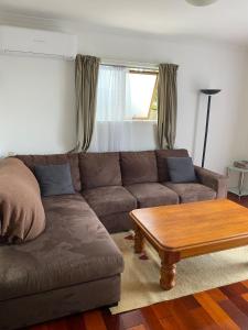 a living room with a couch and a coffee table at Guesthouse in Half Moon Bay in Auckland