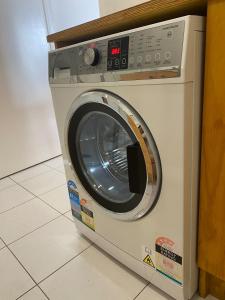 a washing machine is sitting in a room at Guesthouse in Half Moon Bay in Auckland +11 photos
