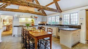 a kitchen with white cabinets and a wooden table at Chalford Manor in Aston Rowant
