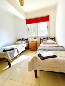 two beds in a room with a window at Pepper House with pool in Argaka +56 photos