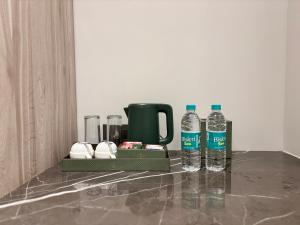 ein Tablett mit zwei Wasserflaschen und einem Becher in der Unterkunft The Eastern Grace Hotel in Buxar