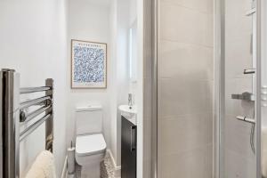 a white bathroom with a toilet and a shower at The Guildford Manor - Free Parking - 6 Beds in Stoughton