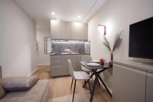a small kitchen with a table and chairs in a room at Stylish gray studio near the city center in Vilnius +9 photos