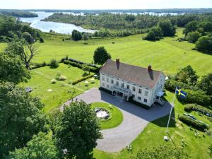 una vista aerea di una casa bianca su un campo verde di Osaby Säteri a Tävelsås