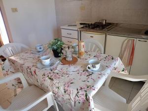 a table with cups and saucers on it in a kitchen at Centro Vacanze Mirage in Torre di Palme