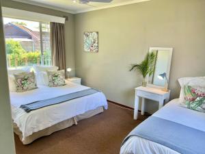 a bedroom with two beds and a window at St Lucia Holiday Cottage in St Lucia