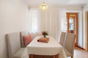 a dining room table with a white table cloth and chairs at Fröhlichhof Wohnung Pink Lady in Lagundo