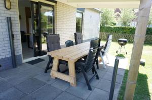 a wooden table and chairs on a patio at Kustverhuur, Park Schoneveld Stern 253 in Breskens +17 photos