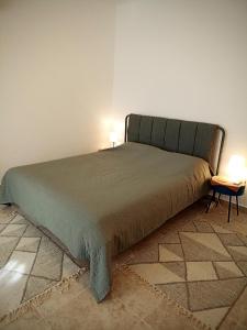 a bed in a room with two lamps on a table at Green Village studio in Gornji Orahovac +26 photos