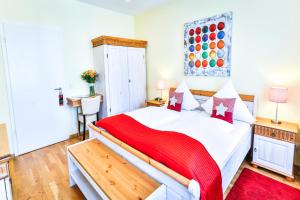 a bedroom with a bed with a red blanket on it at Hotel zum Goldenen Löwen in Baden-Baden
